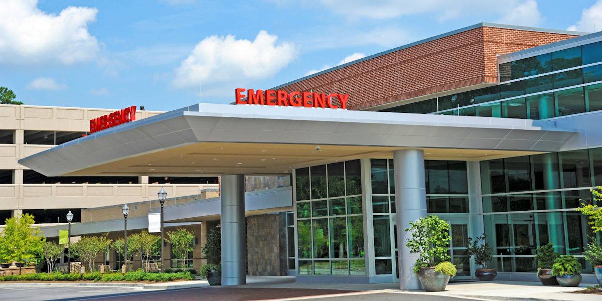 outside of an emergency room building with a large red emergency sign at the top